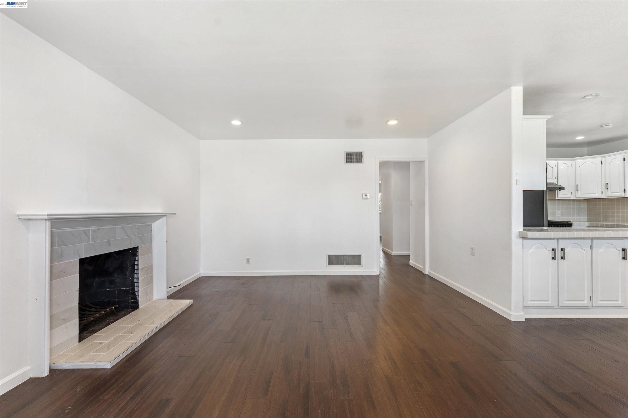 Living room with brick fireplace and hardwood-look floors