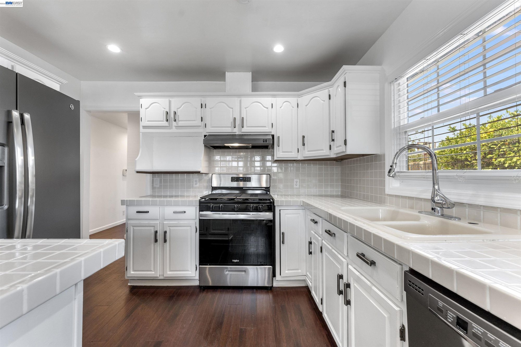 Kitchen with stainless gas range and white cabinetry