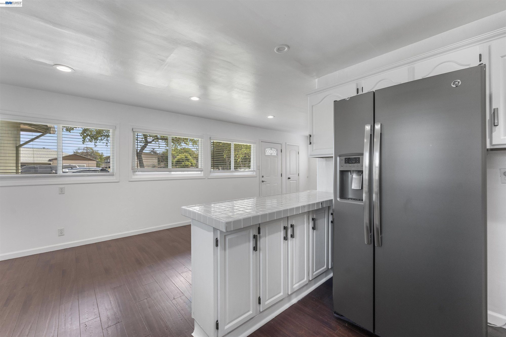 Breakfast bar with tile counters and stainless refrigerator